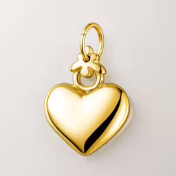 a golden charm shaped like a heart,the heart charm is shown on a white background
