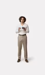 a man with a curly afro stands looking forward
