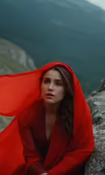 a woman is sitting on top of a mountain