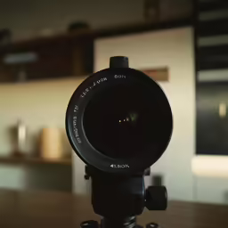 the camera lens on top of a tripod in a kitchen