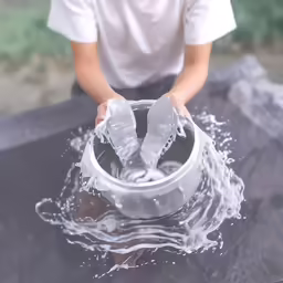the man is pouring water from a plastic container