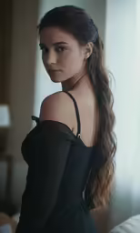a woman posing by the window, in her evening dress