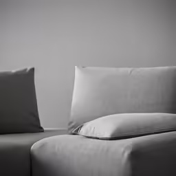 a sofa and ottoman in a room with two pillows