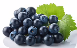 a bunch of blueberries with green leaves