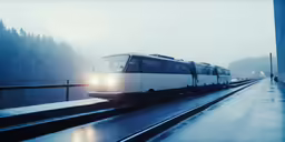 the passenger train is on the tracks in the rain