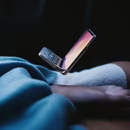a woman holding an cell phone on her left hand