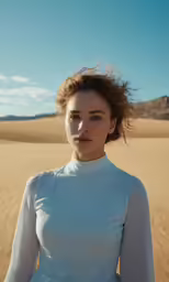 an attractive woman is standing in the desert