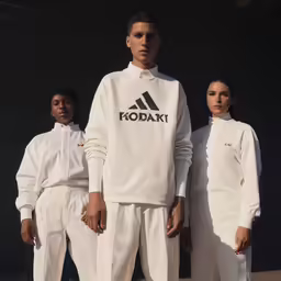 three people in white clothing posing for the camera