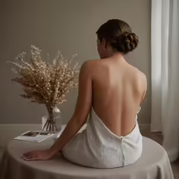 a woman in white top sitting on a round table