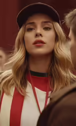 a woman with blonde hair wearing a black hat