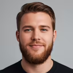 the bearded man smiles into the camera