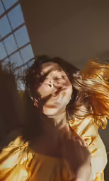 a woman who is blowing a hair in the air