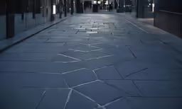 an empty street with a lot of doors next to it