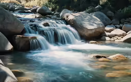 a water fall surrounded by rocks and boulders