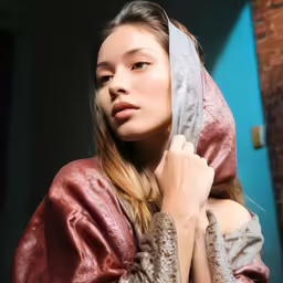 a woman is dressed in a robe and is standing near a building