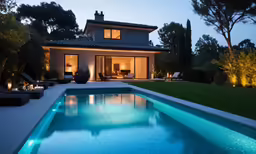 a swimming pool with lights in the middle at dusk