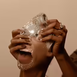 a woman with makeup is covering her face