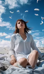 a woman sitting on top of a white blanket