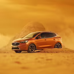 an orange suv driving along a dirt covered road
