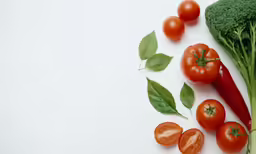 some green broccoli tomato and lettuce next to a leafy vegetable