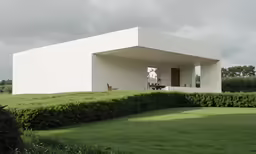 a house on the grass and bushes in front