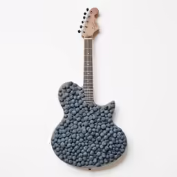 a guitar made out of pills next to it