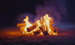 a large fire blazing in a dark outdoor area