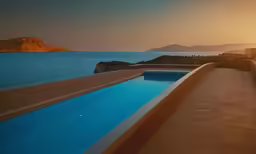 a long swimming pool with a sunset view
