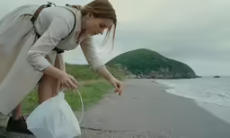 a woman on a beach holds a bag