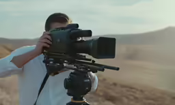 a man holding a video camera up to the lens