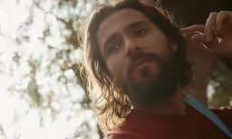 there is a man with long hair and beard holding a frisbee