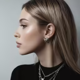 a woman wearing several necklaces and a pendant