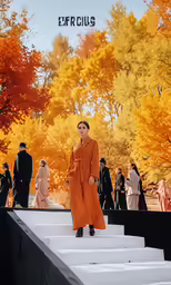 woman in orange dress walking down steps towards a tree line