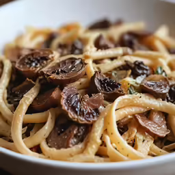 a close up of a bowl of noodles with mushrooms