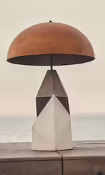 a light on a cement wall near the water