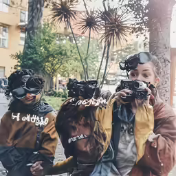 two people taking pictures on their own with the same camera