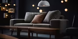 a grey sofa with some dark pillows and lights in the background