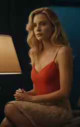 a woman in a red top is sitting in a room