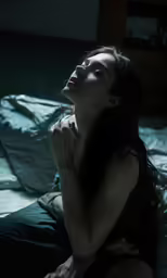 the woman is sitting on a bed with no sheets