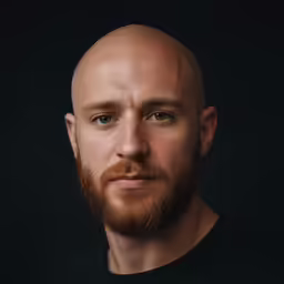 a bald man with blue eyes and a beard