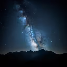 a dark sky with mountains and stars at night