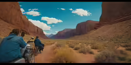 people riding bicycles on a dirt road in the desert