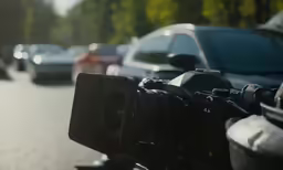 the camera is sitting on the sidewalk by the car