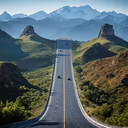 aerial view of an empty highway surrounded by mountains