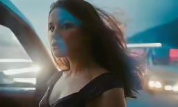 a woman wearing a sequin top drives by an suv