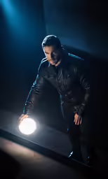 a man with his arms out while holding a bright object