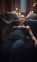 a woman in black is laying on a couch