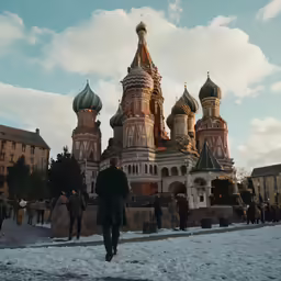 people walk along the path outside a building on a snow covered field