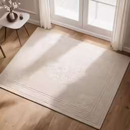 a large white rug on top of wooden floors