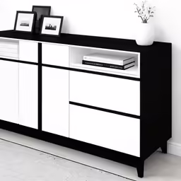 a cabinet with drawers, pictures and a vase on top